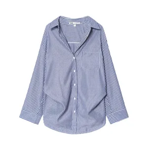 Dettaglio di una camicia a righe bianche e blu con maniche a pipistrello e colletto.