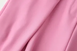Detailed macro shot of smooth pink twill fabric texture for women's casual wide-leg trousers