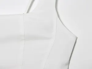 Detailansicht der Stoffstruktur und Nähte eines weißen ärmellosen Bodycon-Kleides.
