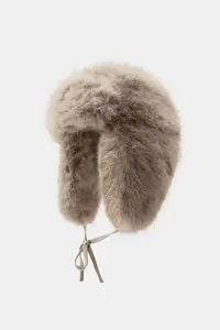 Close-up of a plush faux fur trapper hat with warm earflaps and adjustable ties.