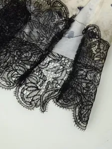 Primo piano del bordo in pizzo nero intricato e della trama del tessuto in raso a fiori