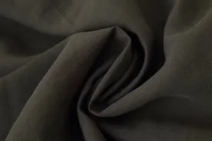 Close-up macro view of the dark gray diagonal twill fabric texture for casual trousers.