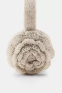 Detailed macro view of a knitted beige earmuff featuring a handmade rose pattern