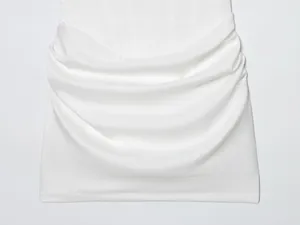 Detailansicht eines weißen Bodycon-Kleides mit elegant drapierter Stoffstruktur