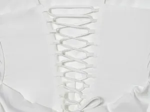 Detaillierte Nahaufnahme des weißen Schnürdetails an einem Bodycon-Trägerkleid