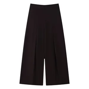Detail shot of black high-waisted wide-leg trousers featuring elegant front pleats