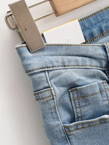 Vue détaillée d'un jean délavé montrant les coutures de la poche et la taille