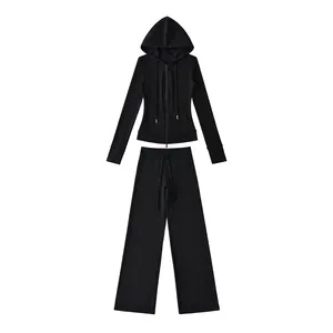 Zwarte tweedelige yogaset met hoodie met rits en joggingbroek met wijde pijpen.