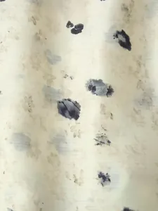 Vista macro della stampa floreale vintage e macchie di inchiostro su tessuto di raso liscio