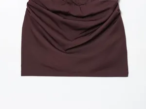 Detailansicht der gerafften braunen Stoffstruktur und hochwertigen Nähte eines Bodycon-Kleides