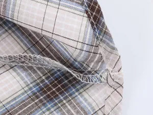 Detalle macro de la costura overlock y el tejido a cuadros de una falda