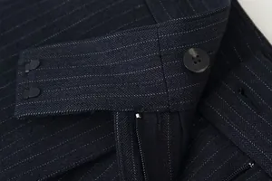 Macro detail of navy pinstripe trousers waistband featuring black button and zipper