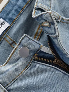 Gros plan détaillé d'un jean bleu clair avec fermeture éclair et bouton en métal