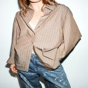 Vista dettagliata di una camicia a righe marroni con maniche a pipistrello da donna