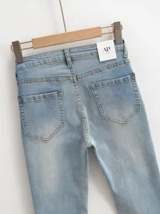 Gros plan détaillé d'un jean bleu clair délavé à taille haute avec poches arrière et coutures.