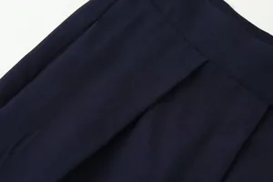 Close-up macro view of navy blue pleated trousers fabric texture and fine stitching