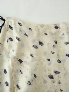 Primo piano dell'elegante stampa floreale su tessuto di raso crema per gonna