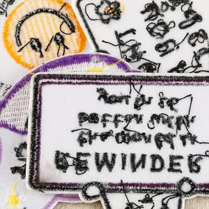 Close-up of high-quality embroidered DIY patches with floral and text designs for bags