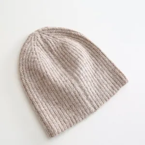 High-quality close-up of a warm oatmeal-colored ribbed knit beanie for winter