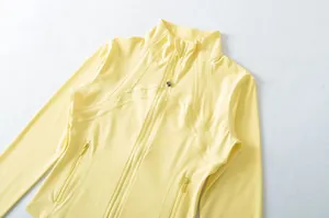Vista dettagliata delle cuciture e della zip di una giacca sportiva da yoga slim fit giallo chiaro