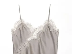 Detailopname van een elegante grijze satijnen camisole met fijn kanten biesje bij de hals
