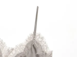 Detail van fijn wimperkant op een grijze zijden satijnen camisole top met dunne bandjes