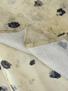 Dettaglio macro di elegante tessuto in raso con stampa floreale scura e cuciture fini