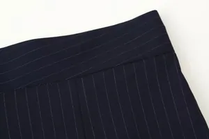Close-up detail of navy blue pinstripe wide leg trousers showing waistband and stitching