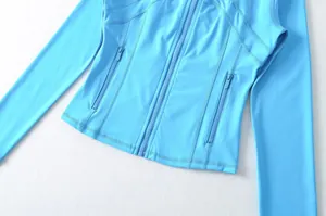 Primo piano della giacca da yoga sportiva azzurra slim con dettagli con cerniera