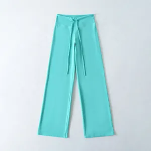 Detailopname van een turquoise yoga-broek met wijde pijpen en trekkoord in de taille.