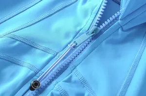 Dettaglio di una giacca sportiva celeste con cerniera e cuciture piatte resistenti