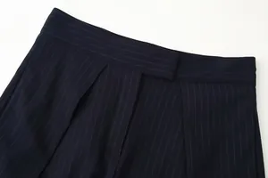 Detail view of navy blue pinstripe wide-leg trousers showing waistband and fabric texture.