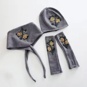 Grey wool winter accessory set including hat, earmuffs, and sleeves with gold embroidery