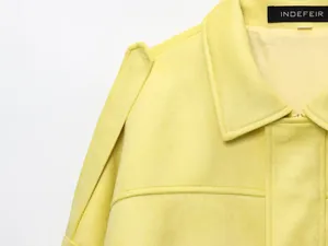 Primer plano de la suave textura de ante y el cuello de esta chaqueta bomber amarilla