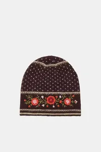 Detailed view of floral embroidery on a dark brown knit beanie hat for winter