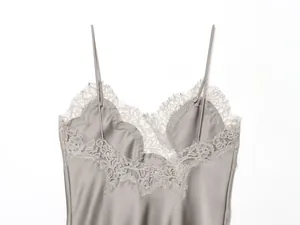 Detailopname van de delicate kanten rand en gladde satijnen stof van deze grijze camisole