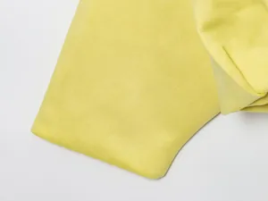Primer plano detallado que muestra la suave textura de ante de la tela del bomber amarillo.