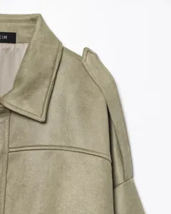 Primer plano de chaqueta bomber de ante verde salvia con detalles en el hombro y cuello