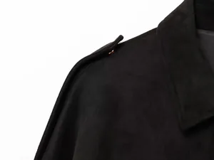 Vista de primer plano de la charretera de una chaqueta bomber negra con botón de metal.