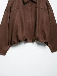 Primer plano de una chaqueta bomber de ante sintético marrón que muestra el tejido y dobladillo
