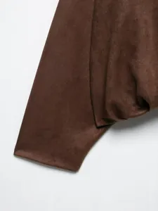 Vista macro detallada de la suave textura de gamuza marrón de una chaqueta bomber de mujer