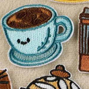 Cute cartoon light blue coffee cup embroidery patch detail on soft beige texture background