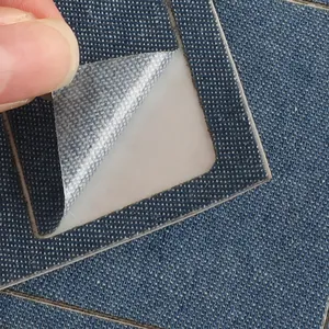 Close-up of a blue denim self-adhesive patch for clothing repair showing the sticky back