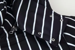 Κοντινό πλάνο ριγέ ασπρόμαυρο μπουφάν με λεπτομέρεια από ασημί μεταλλικό φερμουάρ