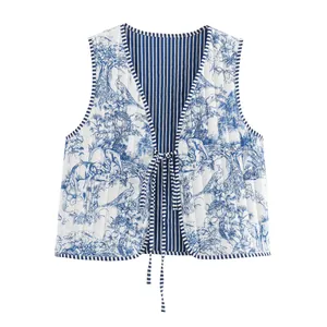 Detail of reversible quilted vest with blue toile de jouy print and striped lining.