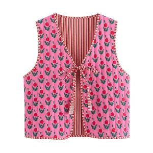 Professional front view of a pink floral quilted vest with tie closure and striped lining