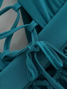 Gros plan détaillé sur le laçage délicat de couleur sarcelle au dos de cette robe femme.