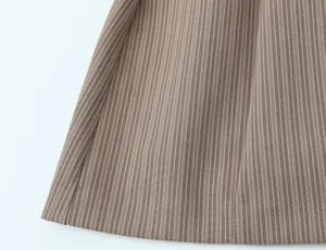 Close-up detail of fine vertical stripes on a stylish brown mini dress fabric