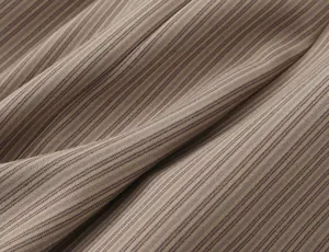 Detailed macro view showing the textured brown striped fabric of the elegant mini dress