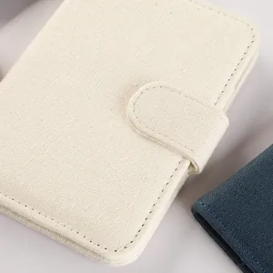Dettaglio ravvicinato di un porta passaporto in tela color crema con trama a vista
